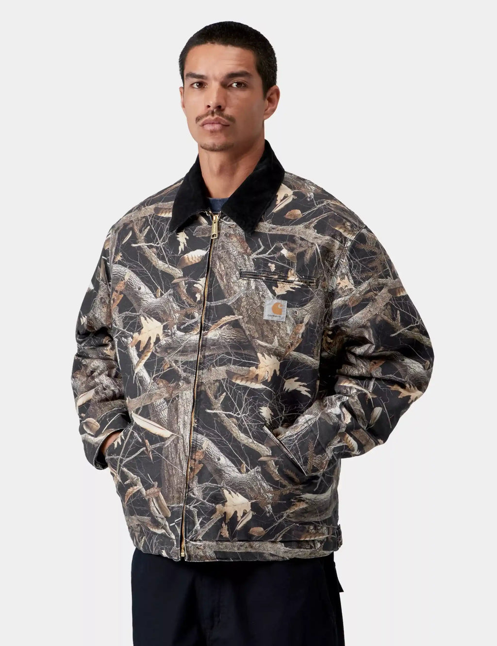 Men's camo feather-pattern work jacket with zip front and black stand collar on model.
