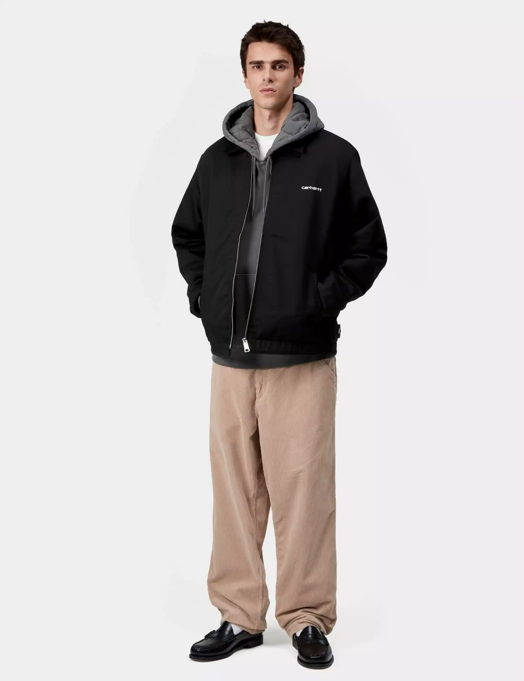 Black hooded jacket worn by model with gray hood lining and zip front