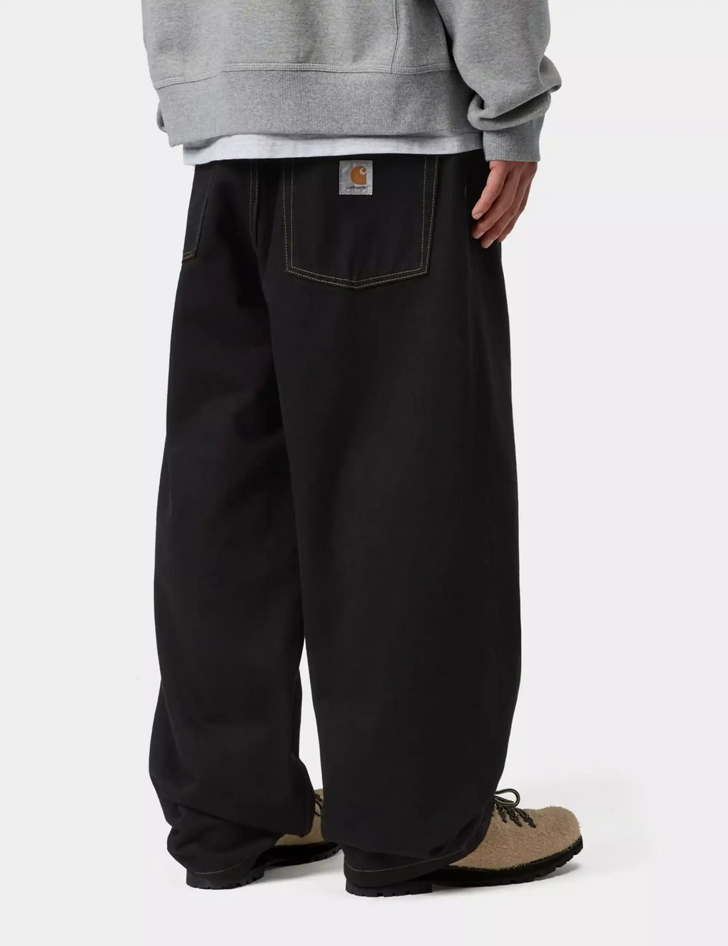 Black denim pants close-up from side with rear pocket and brand patch