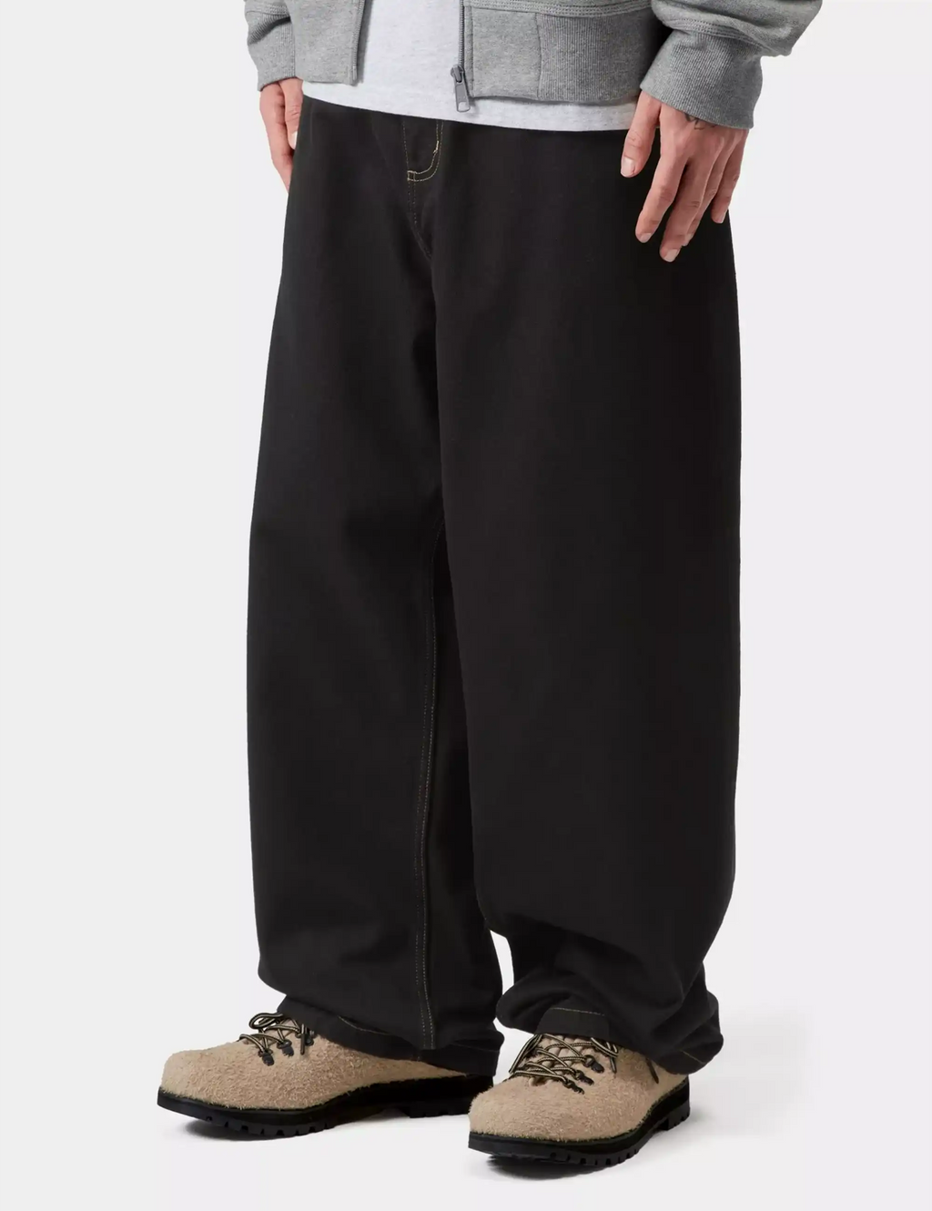 Black denim pants with wide-leg silhouette and side seam; styled with tan boots