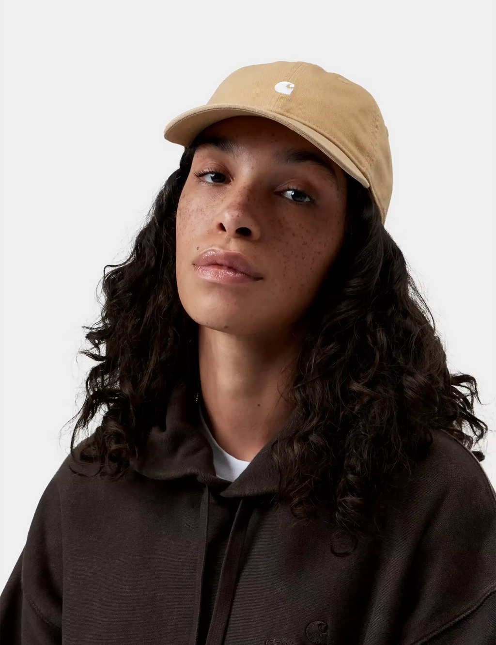 Beige logo baseball cap with curved brim and small white emblem