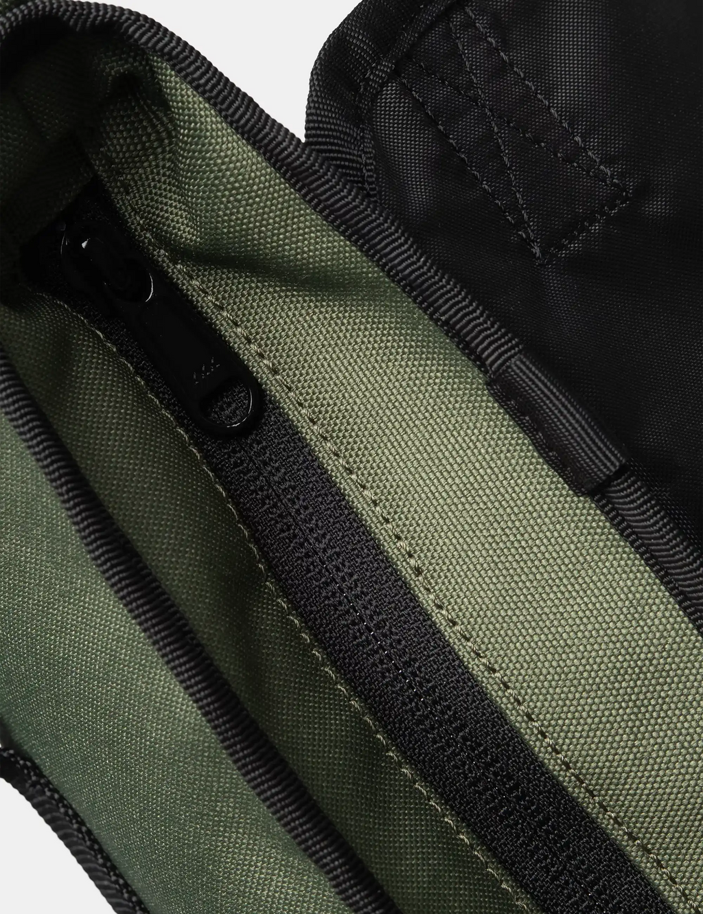 Olive green canvas shoulder bag with black trim and zipper close-up