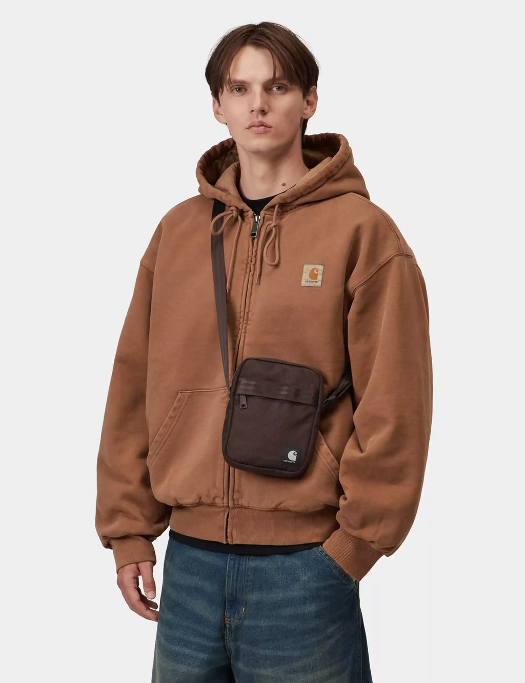 Small dark brown shoulder bag with adjustable strap and front zip pocket