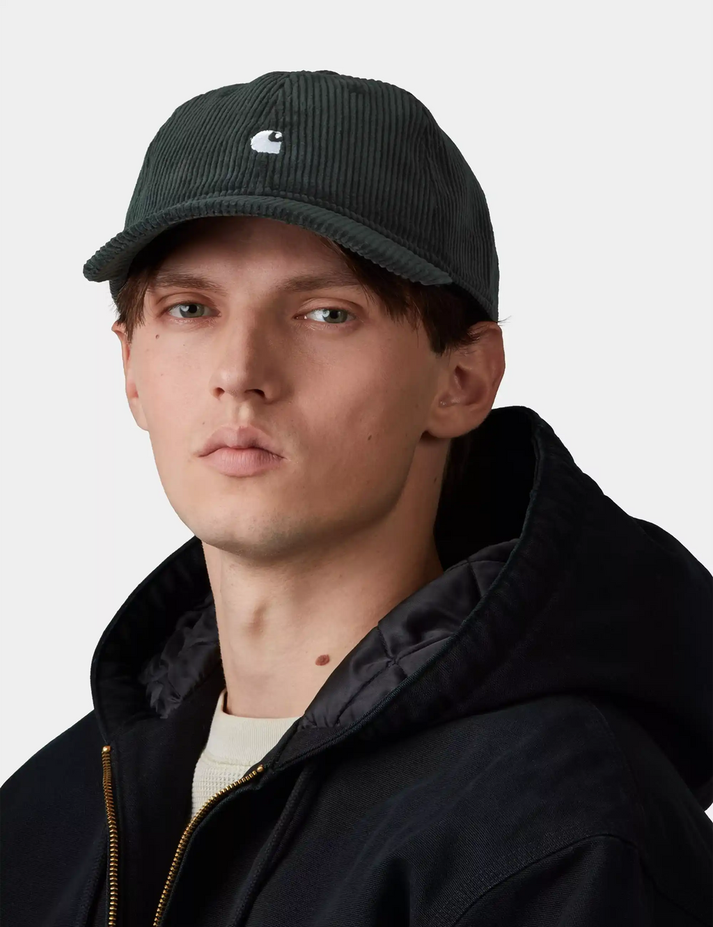 Dark corduroy baseball cap with small white logo on the front panel