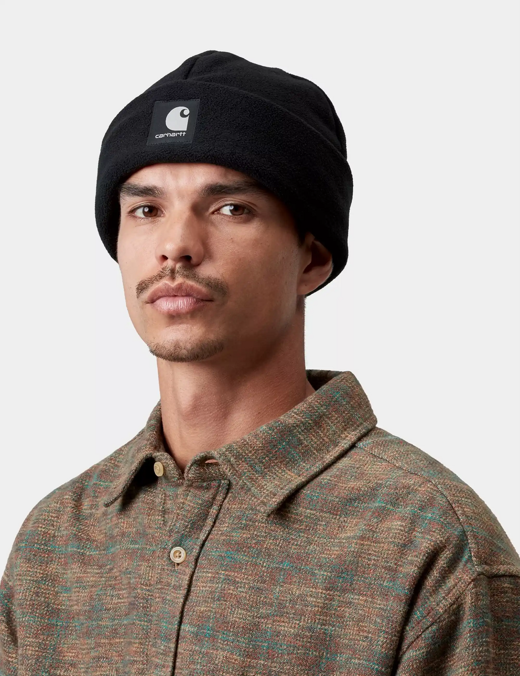 Black knit beanie hat worn by model, side profile