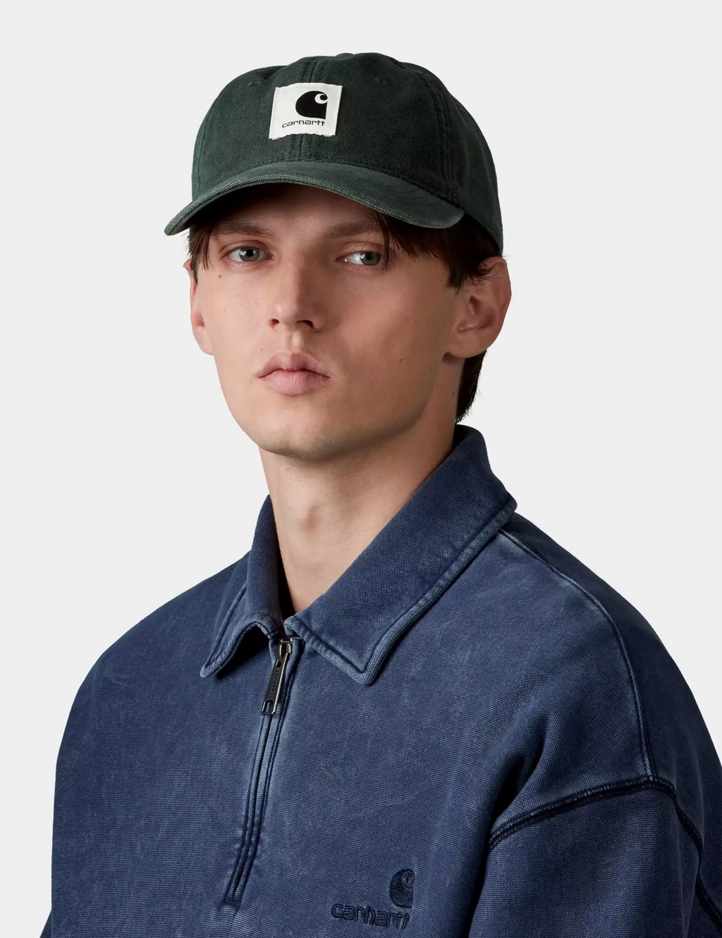 Dark green canvas cap with front logo patch and curved brim