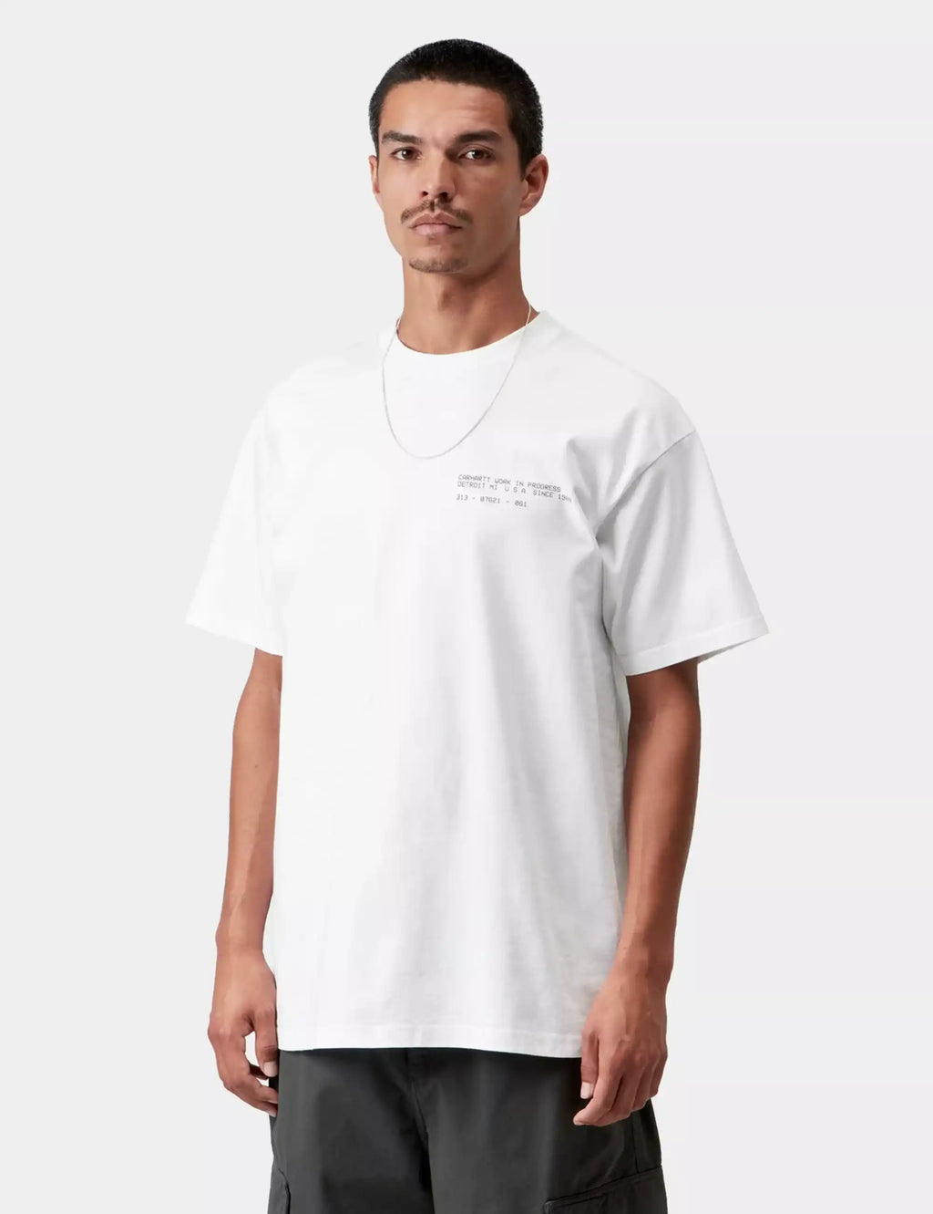White crew-neck T-shirt with small chest graphic print and short sleeves.