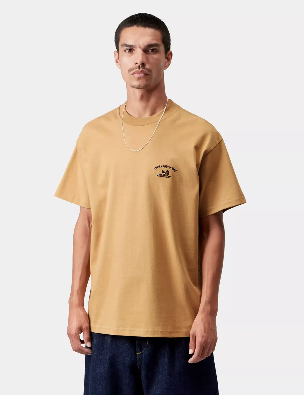 Tan crew-neck T-shirt with chest duck logo, worn by model