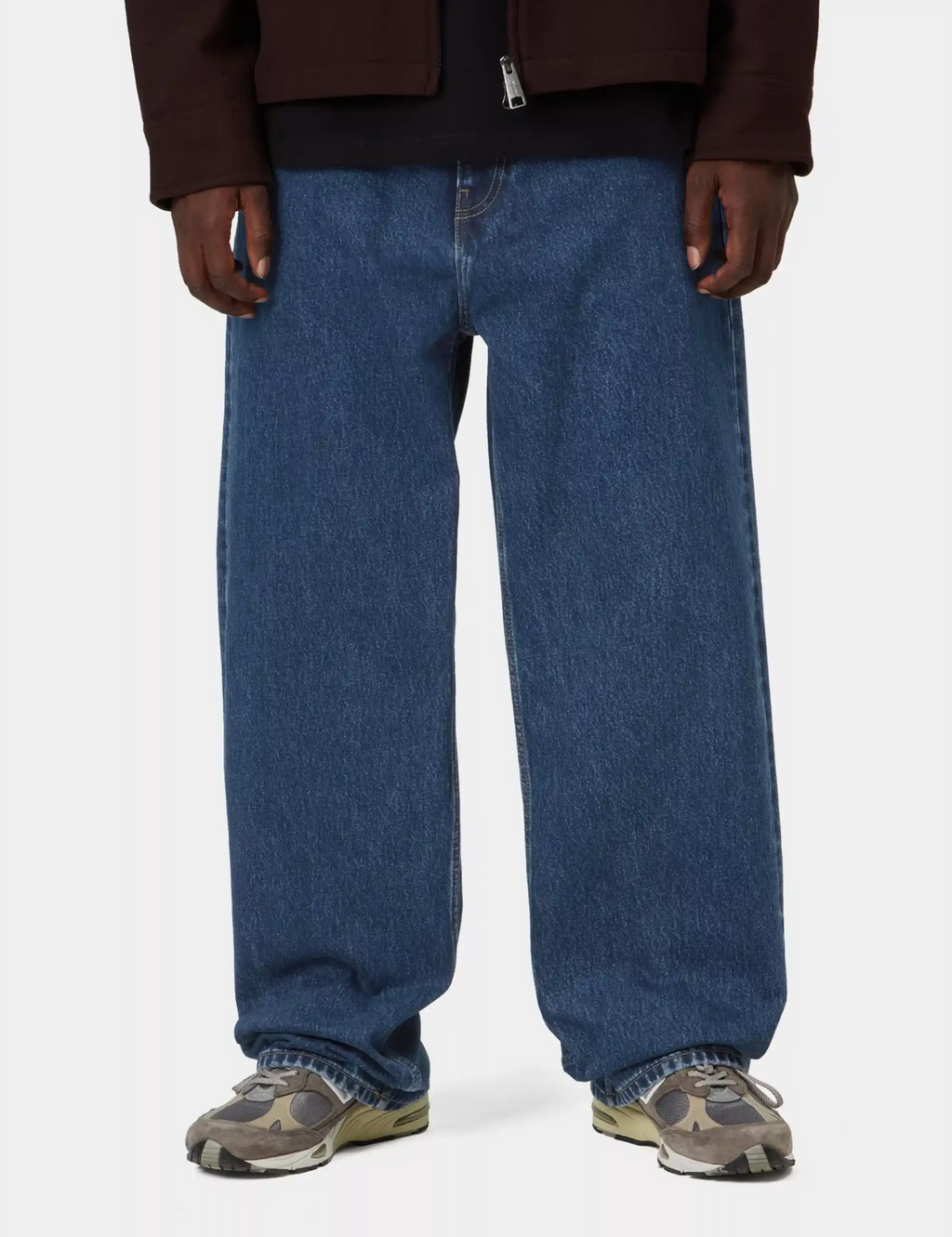 Stone-wash blue denim pants on model, relaxed fit with cuffs and side pockets.