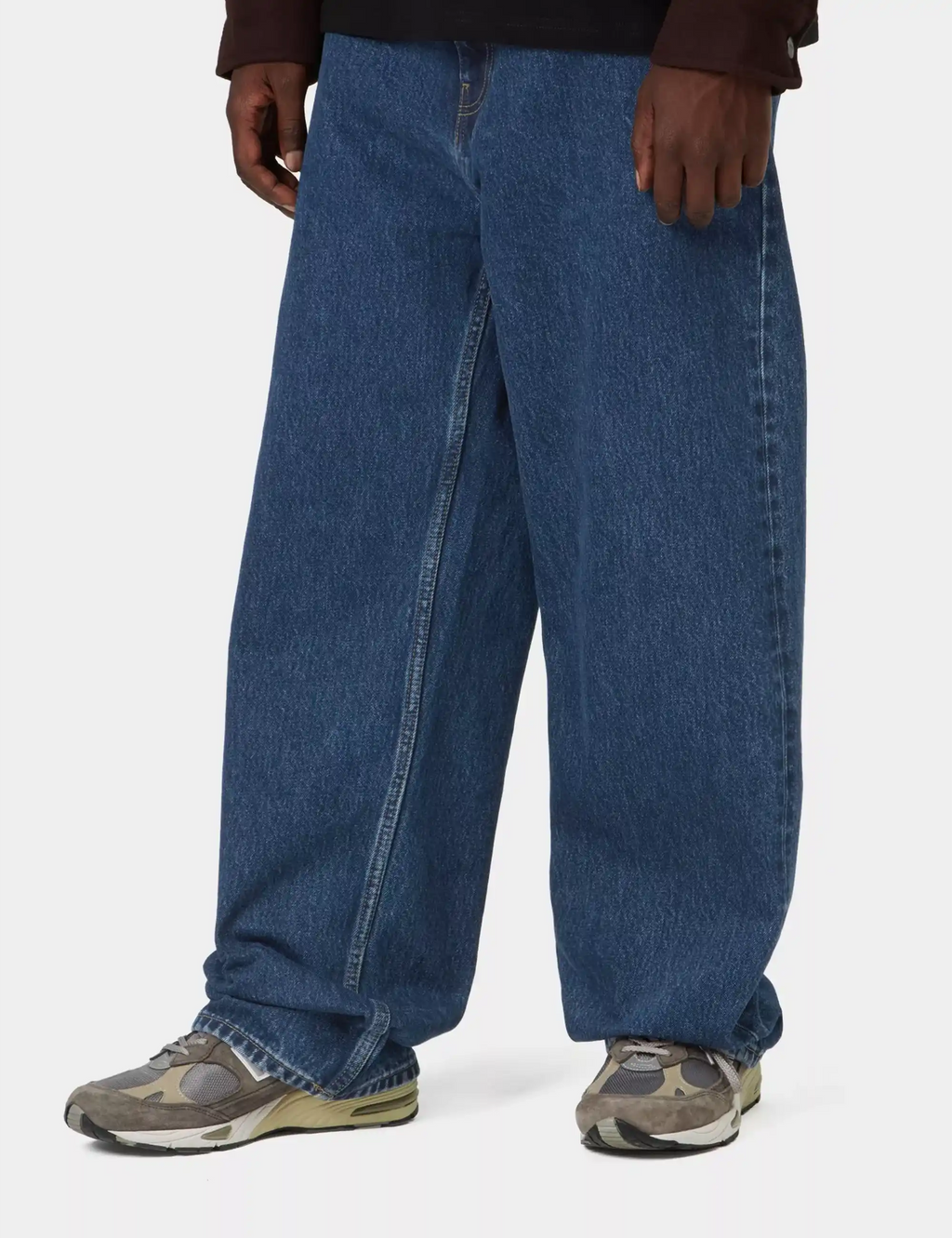 Stone-wash blue denim pants with front fly seam and relaxed wide-leg opening.