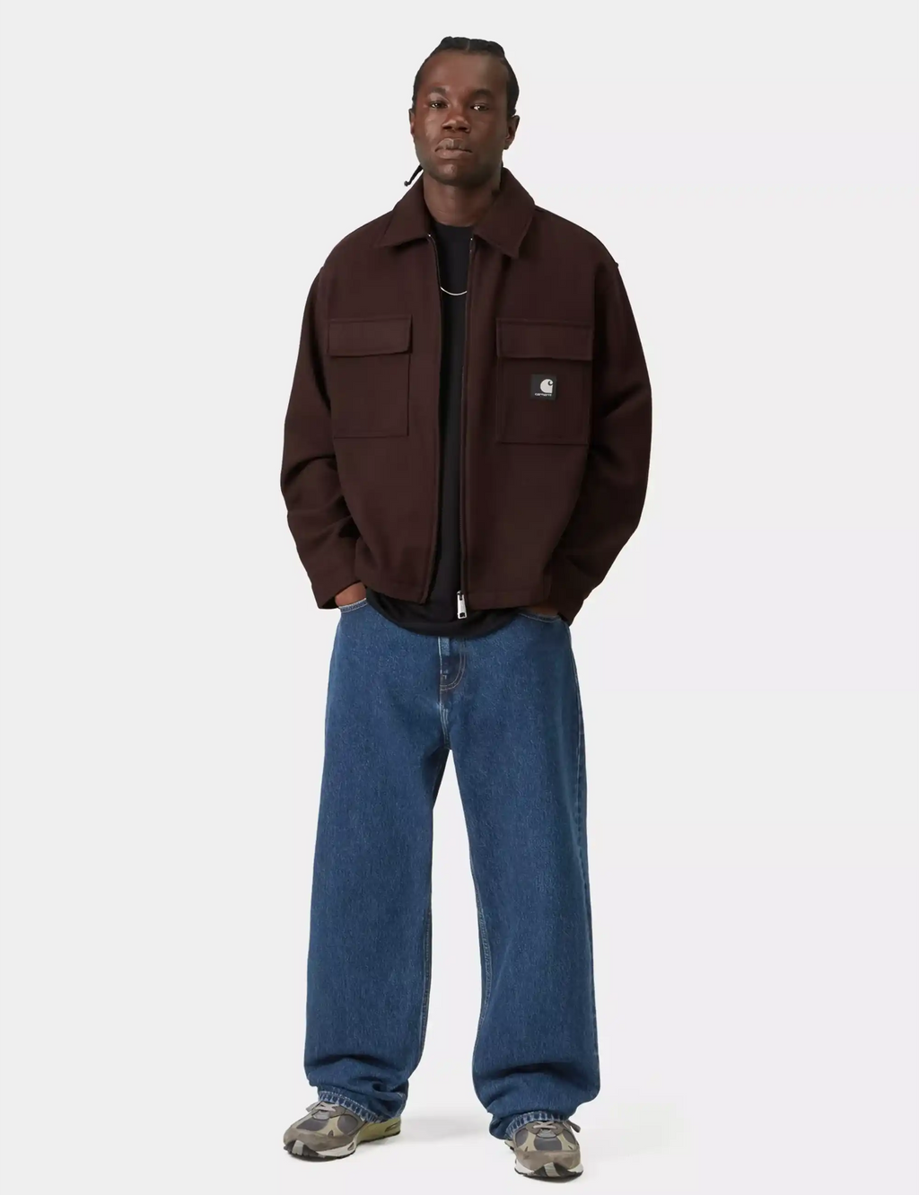 Blue stone-wash denim pants worn on model with relaxed legs and cuffed hem.