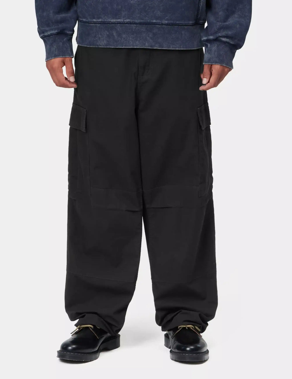 Black cargo pants on model: adjustable cuffs, side cargo flap pockets, relaxed straight legs.