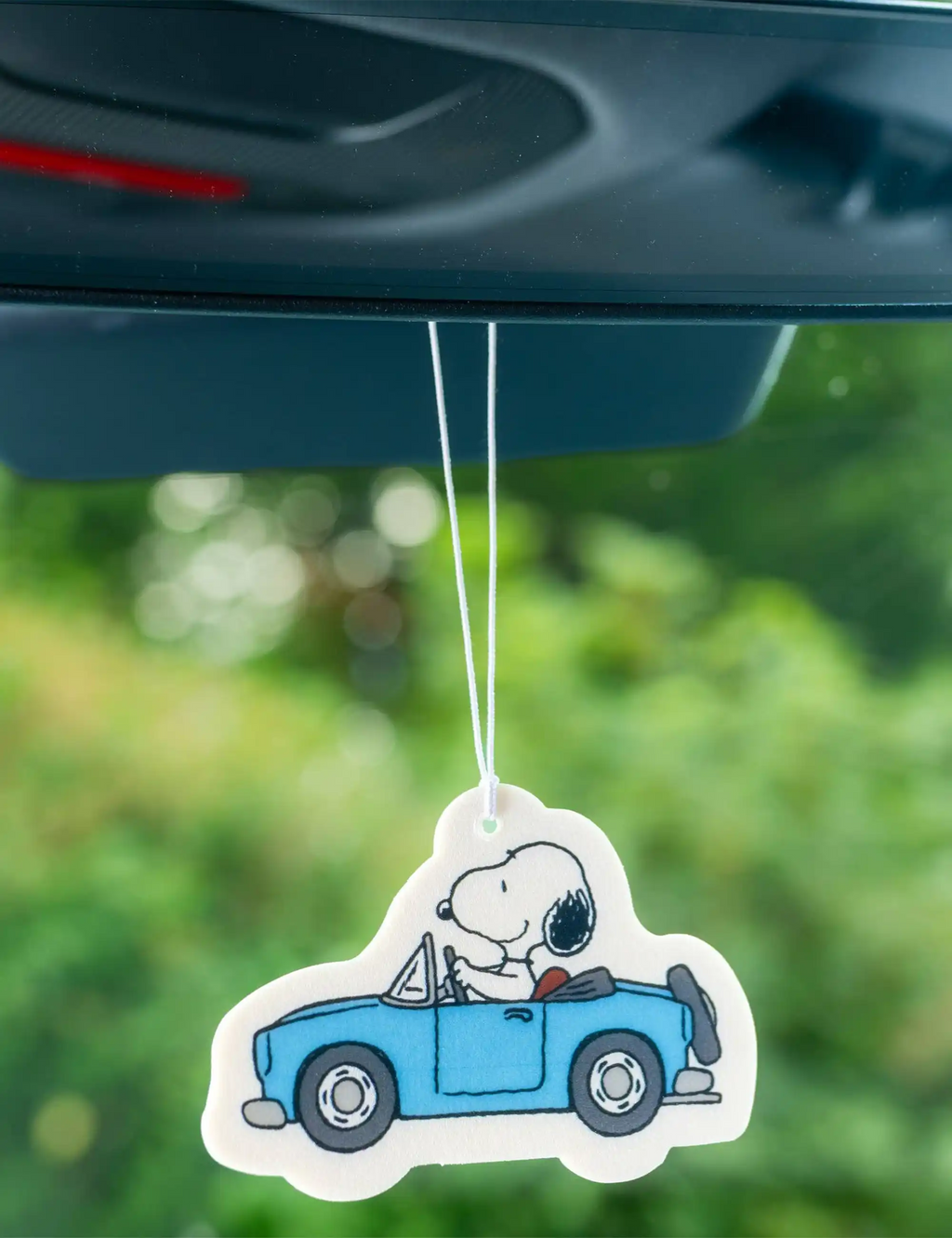 Hanging car air freshener shaped like Snoopy driving a blue car
