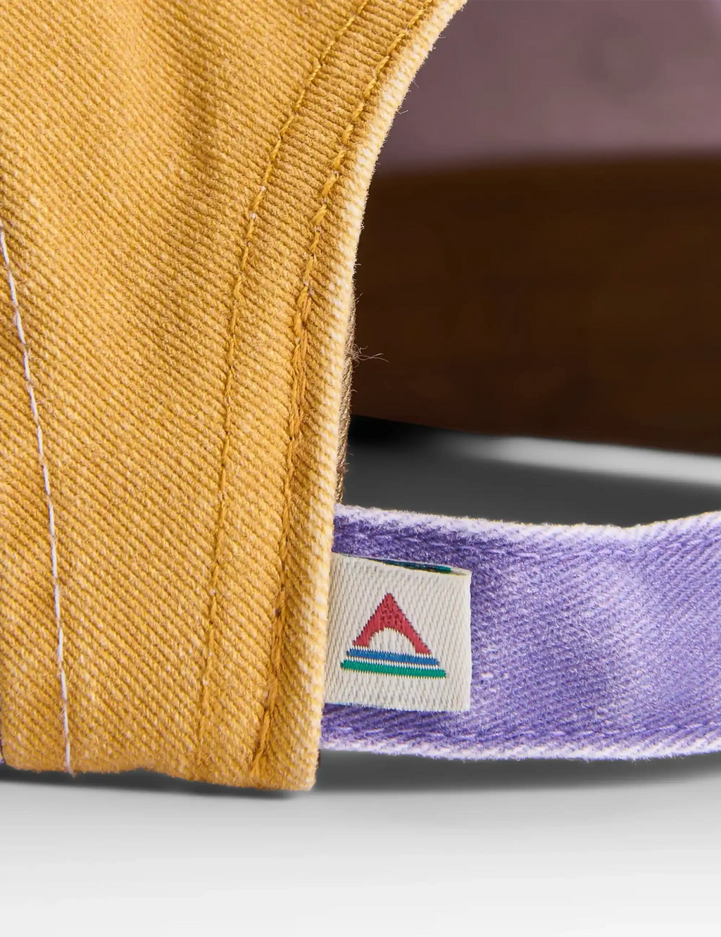 5-panel cap brim detail with purple band and embroidered Passenger logo