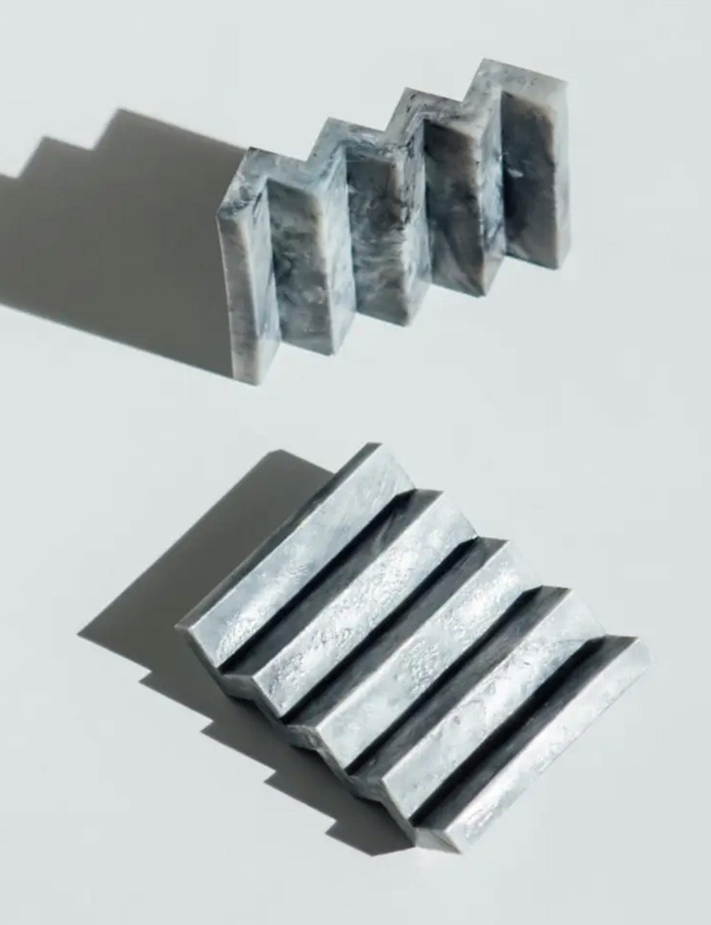 Metallic, textured blocks on a light gray background
