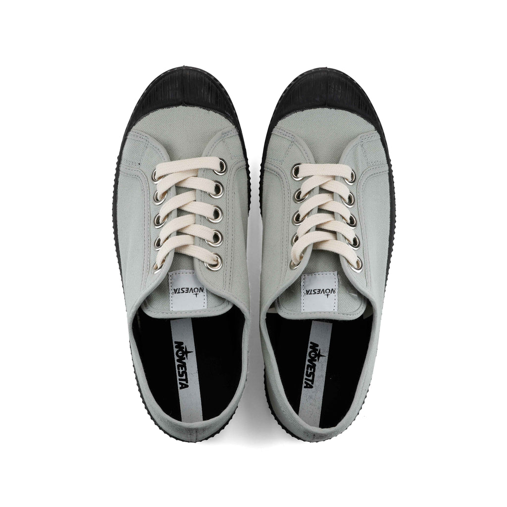 Pair of sage canvas sneakers with black interiors, lace-up front and metal eyelets