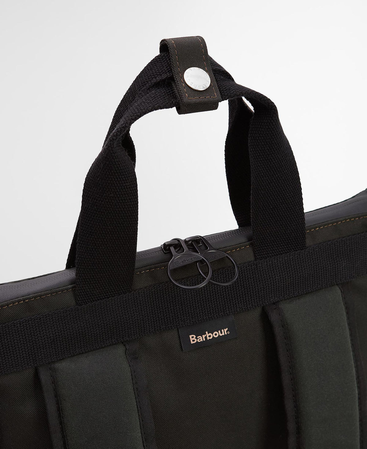 Close-up of backpack top handles, snap tab, zip pulls, and shoulder straps