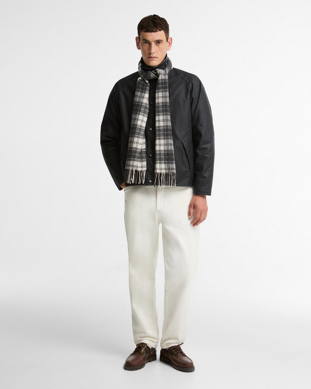 Tartan lambswool scarf in gray and white plaid with fringe, worn with jacket