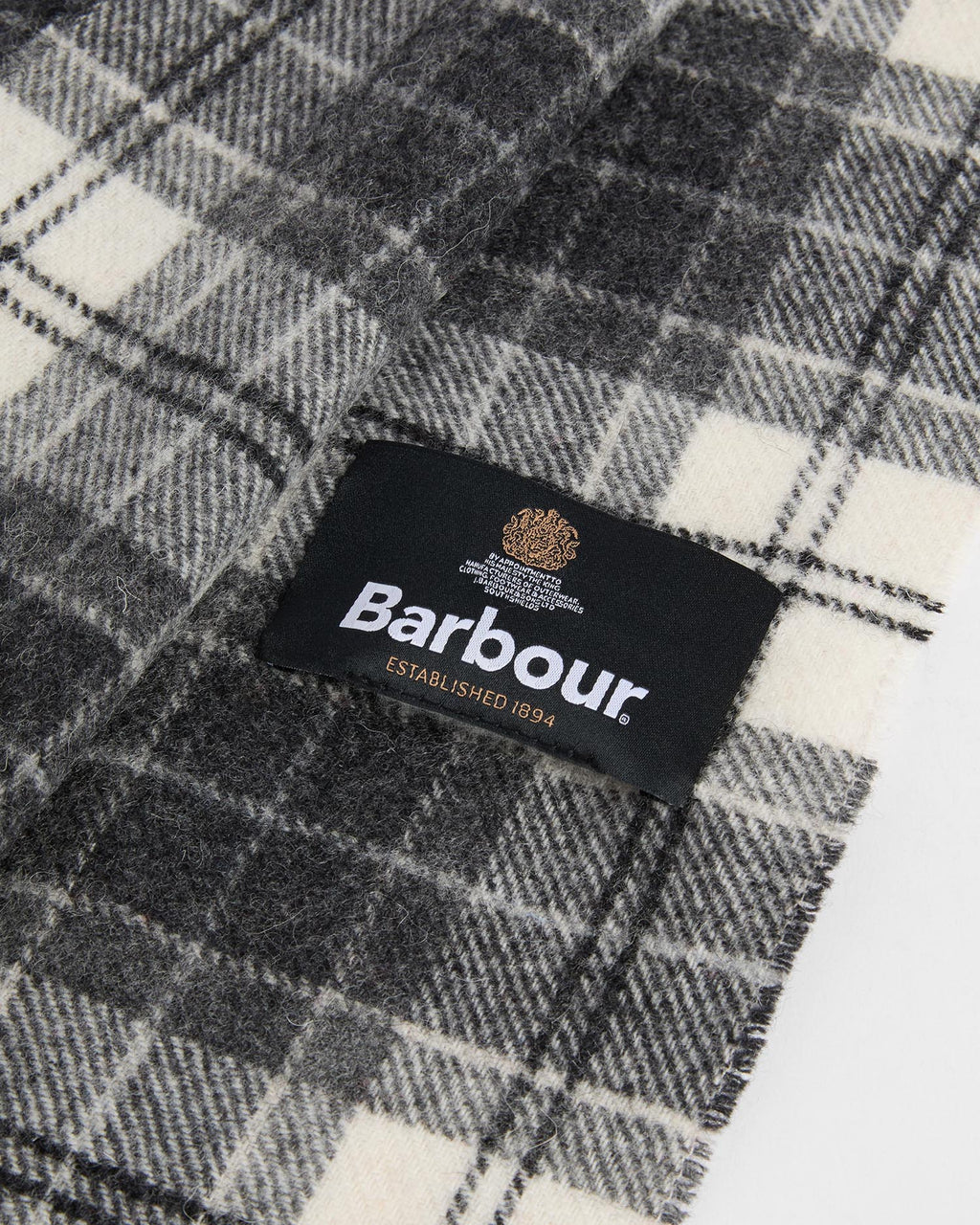 Gray and white tartan lambswool scarf label with Barbour logo on inner end