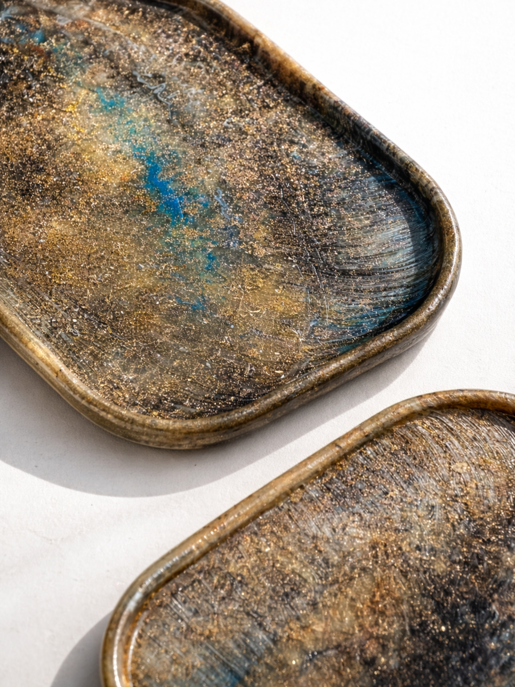 Recycled plastic tray edge close-up, speckled bronze surface with blue flecks.