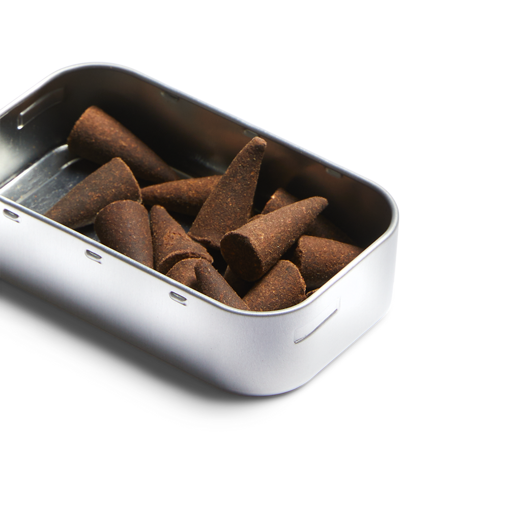 Metal tin filled with dark brown incense cones