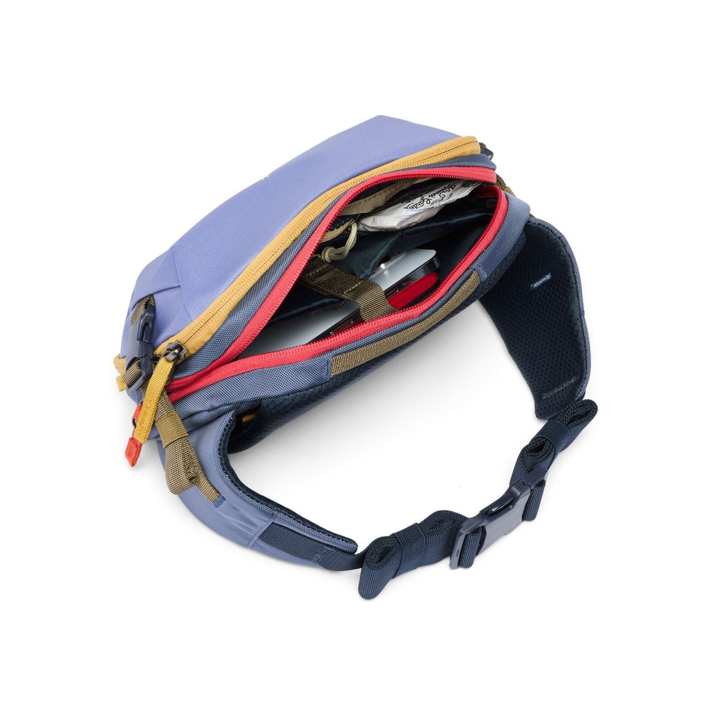 Cotopaxi hip pack open, showing organizer pockets with red and black lining