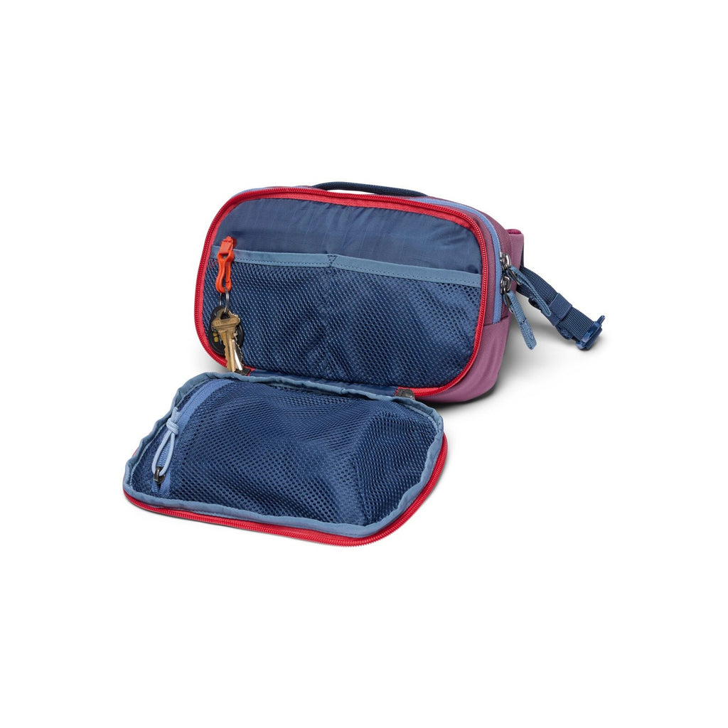Cotopaxi hip pack open, fig purple exterior with two blue mesh-lined compartments