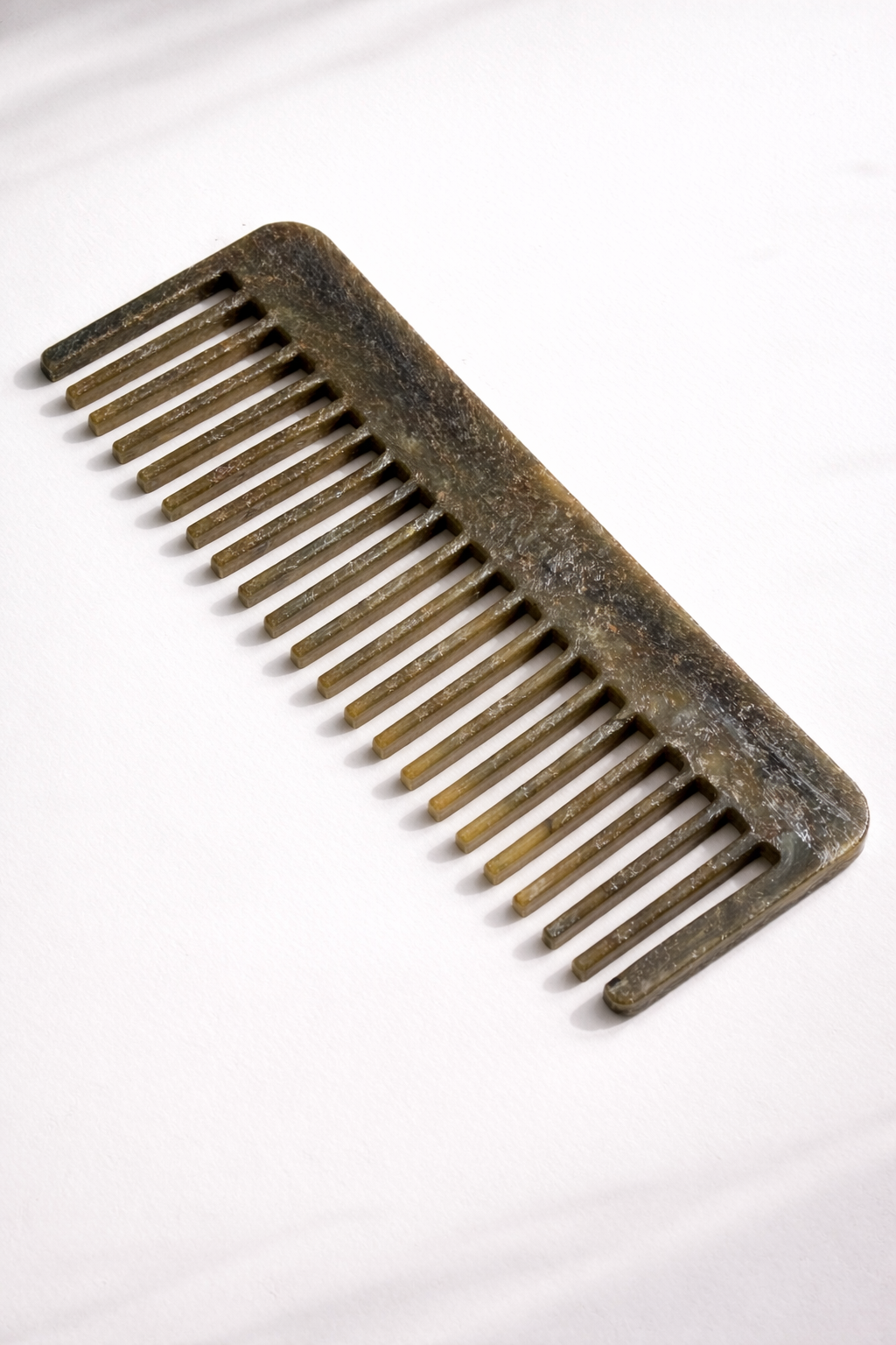 Recycled plastic hair comb, dark, long straight teeth.