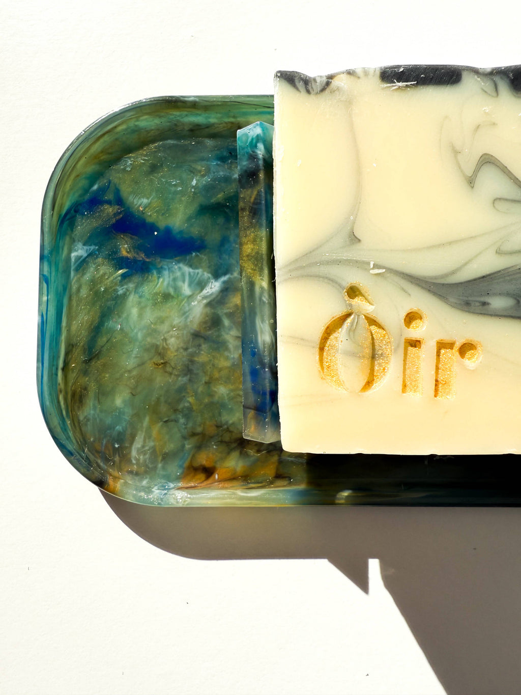 Marbled recycled plastic tray corner and rim, teal-blue marbling with yellow and white