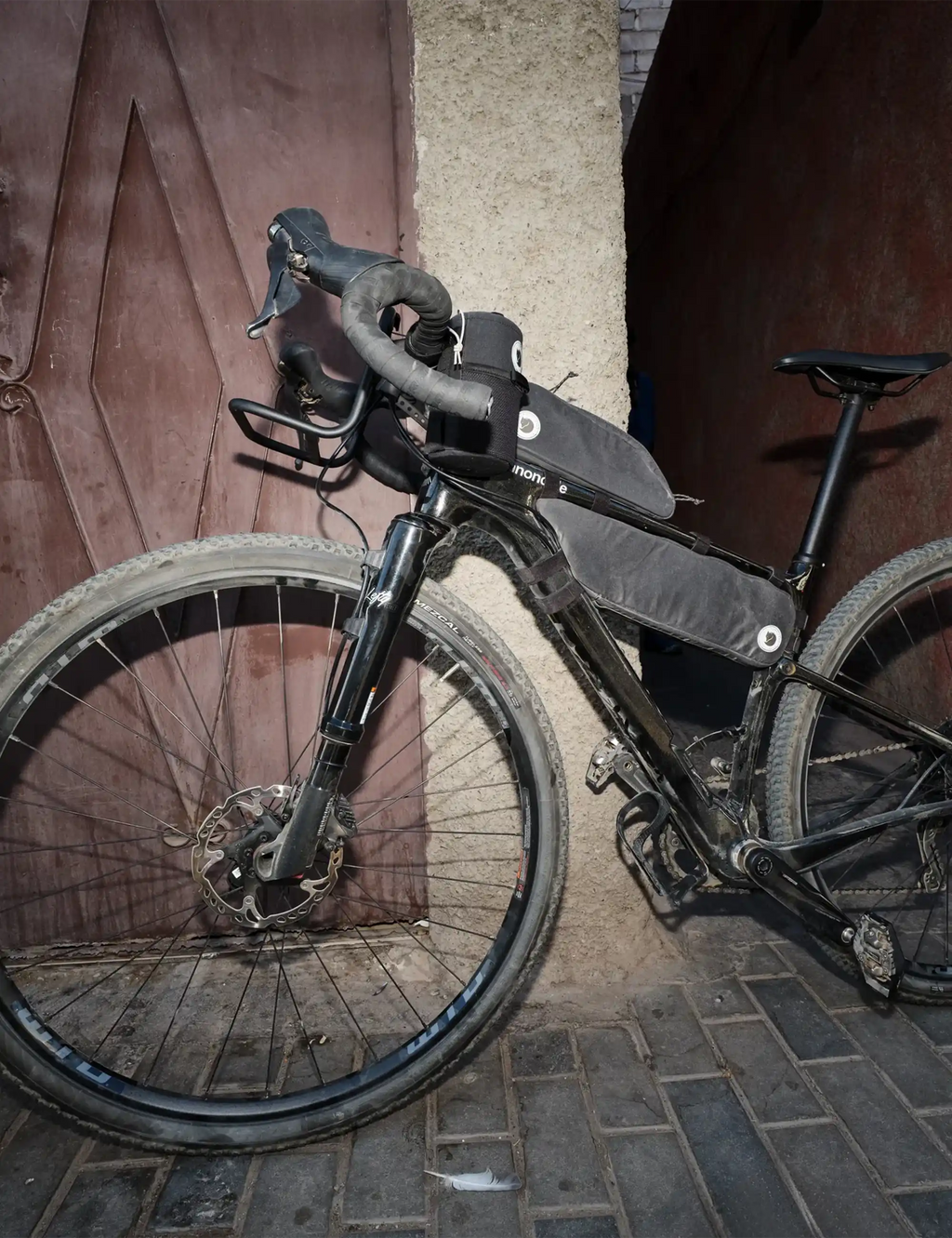 Black handlebar-mounted bike pouch with circular logo patch