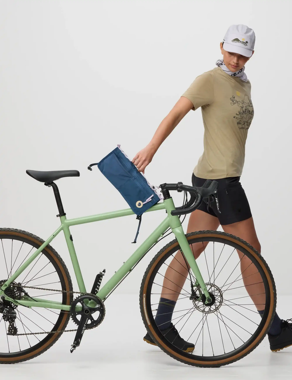 Bike frame fold bag in dark blue attached to bicycle frame with webbing straps.