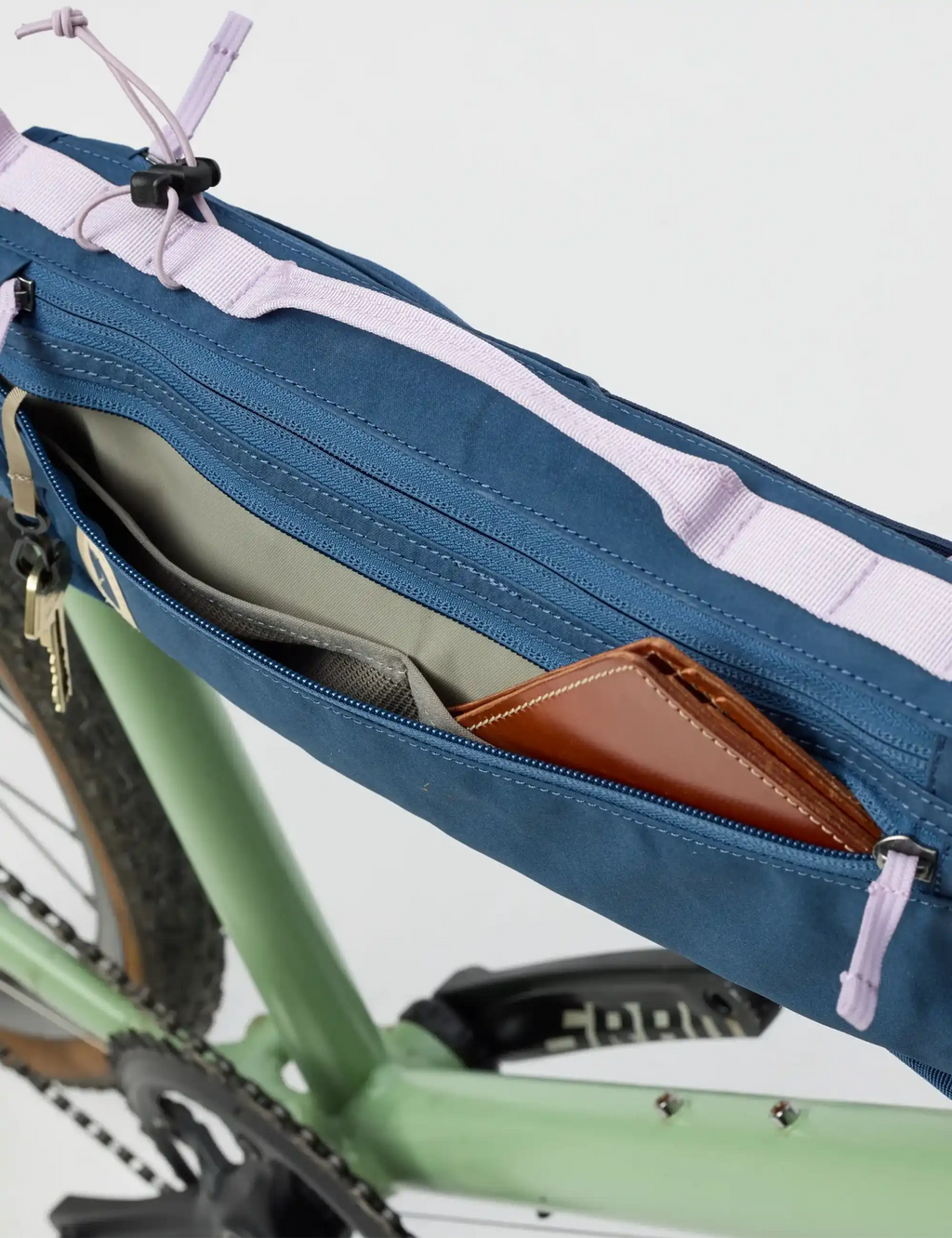 Bike frame fold bag open, blue organizer with striped trim and multiple zip compartments.
