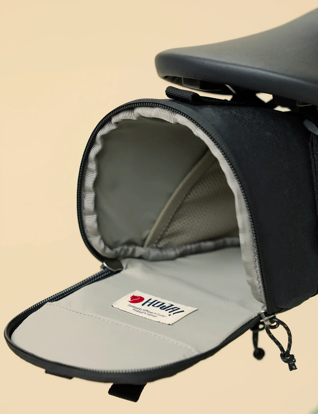Black bike seat bag open with gray interior lining and zipper closure