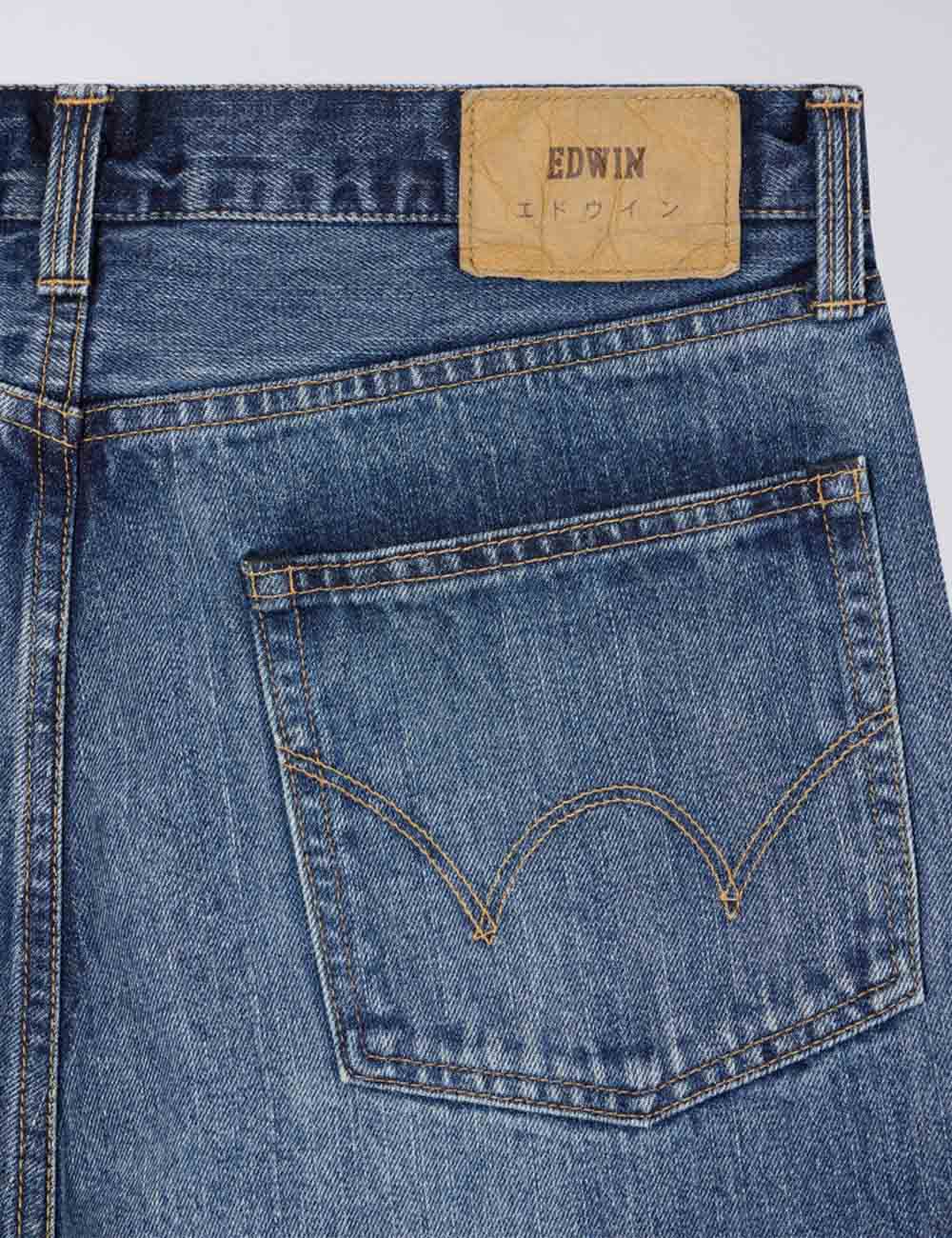 Dark blue denim jeans close-up, back pocket with EDWIN patch and contrast stitching