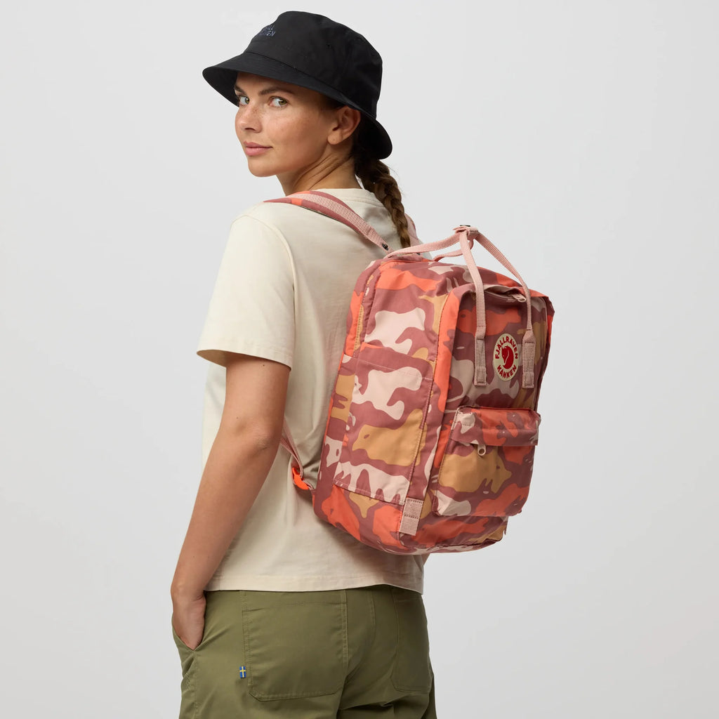Camo rose 15 in laptop backpack worn on model, front patch pocket and carry handle