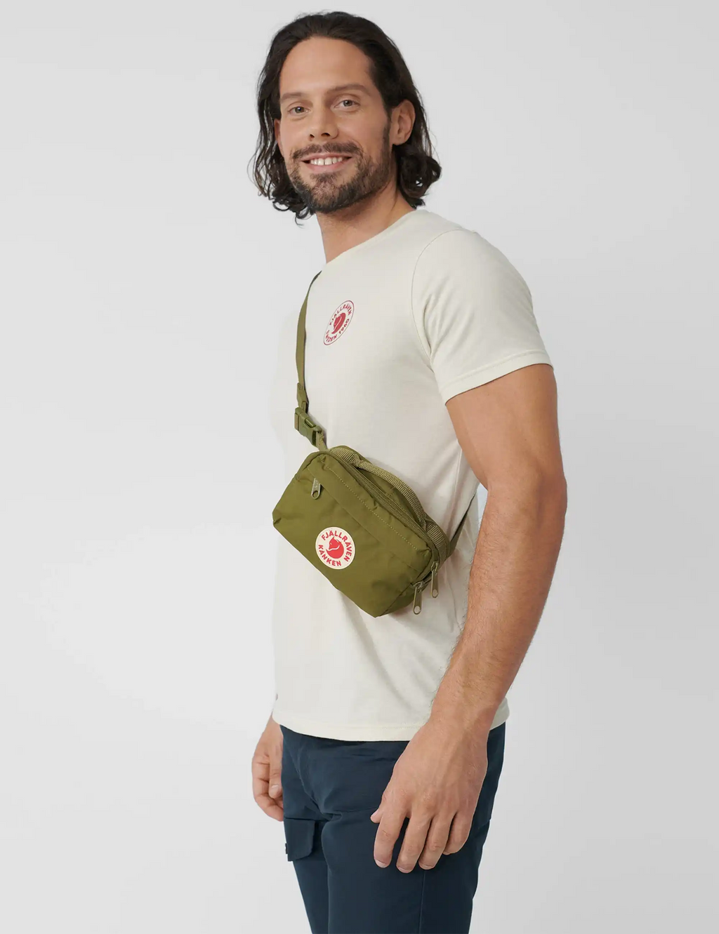 Kanken hip pack worn at waist, olive green with front logo patch and strap