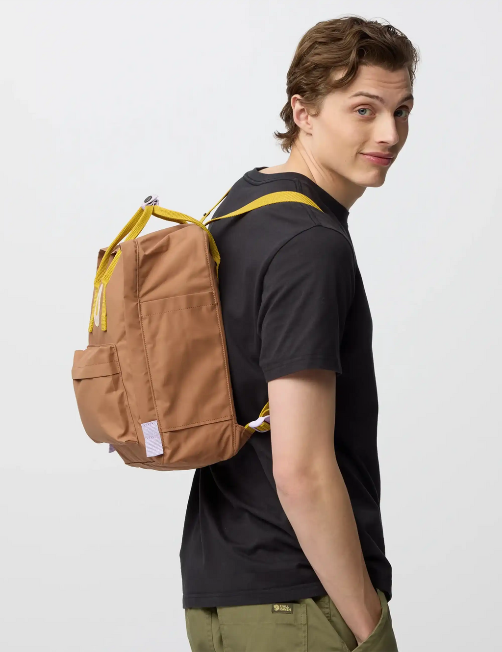 Khaki mini backpack with yellow straps, front zip pocket, and looped cords
