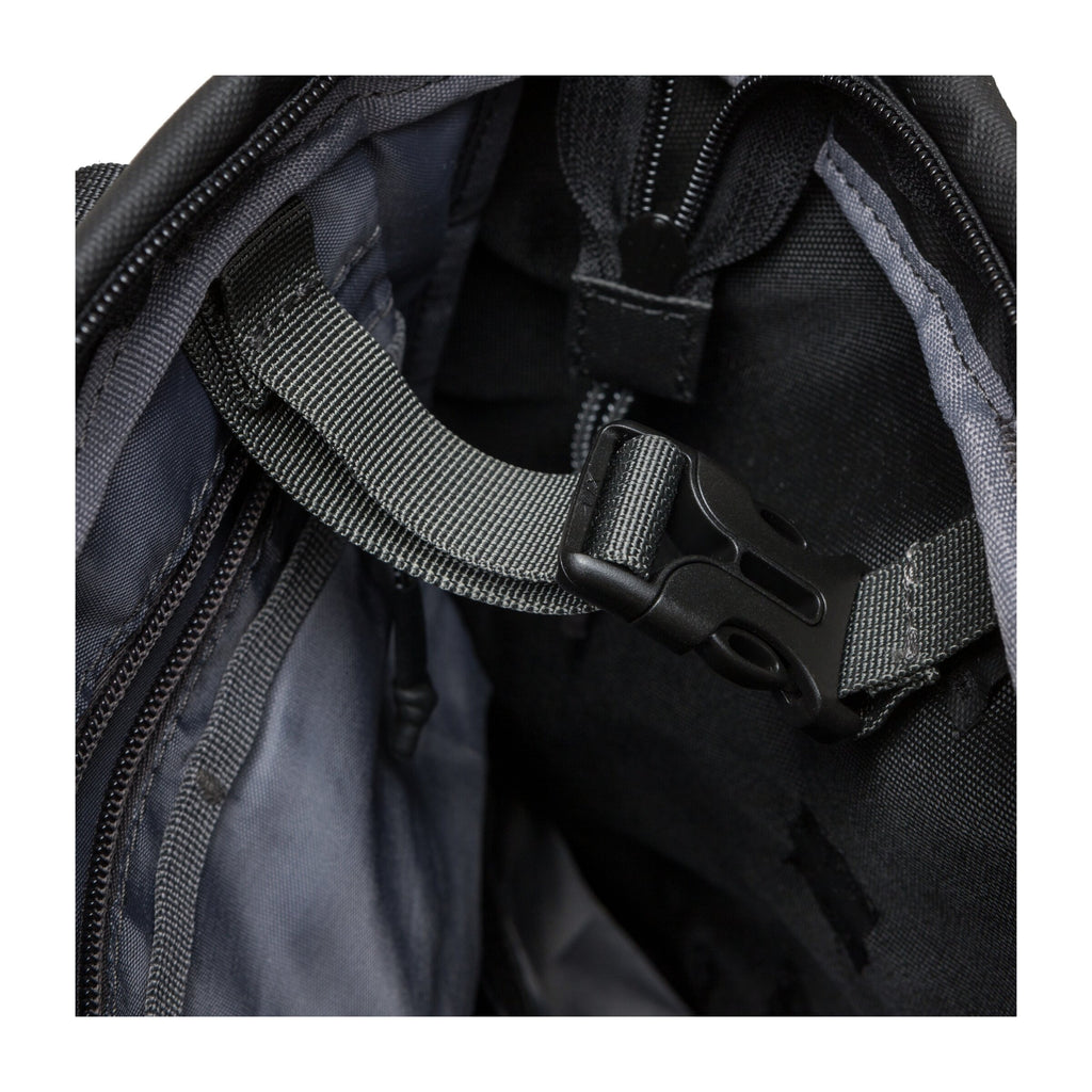 Interior view of black tote backpack showing zipper, webbing strap, and plastic buckle