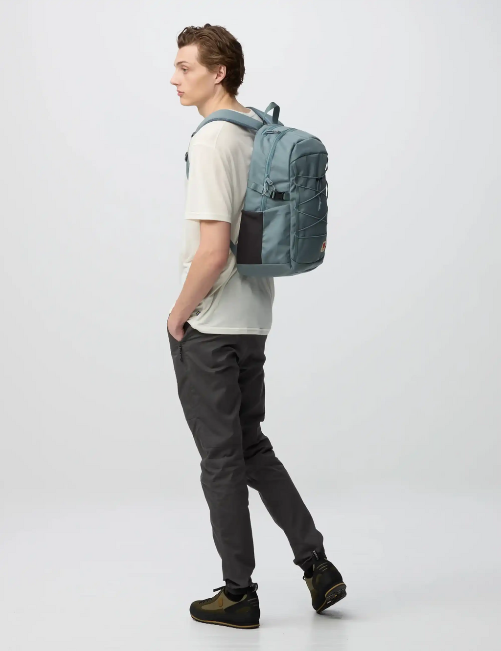 Nimbus blue backpack on person from side view with front pocket and adjustable shoulder straps
