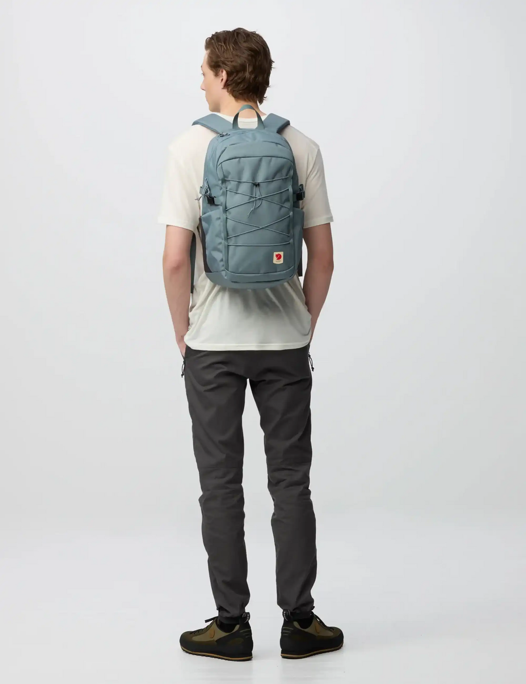 Nimbus blue backpack on person from rear view with padded straps and logo patch