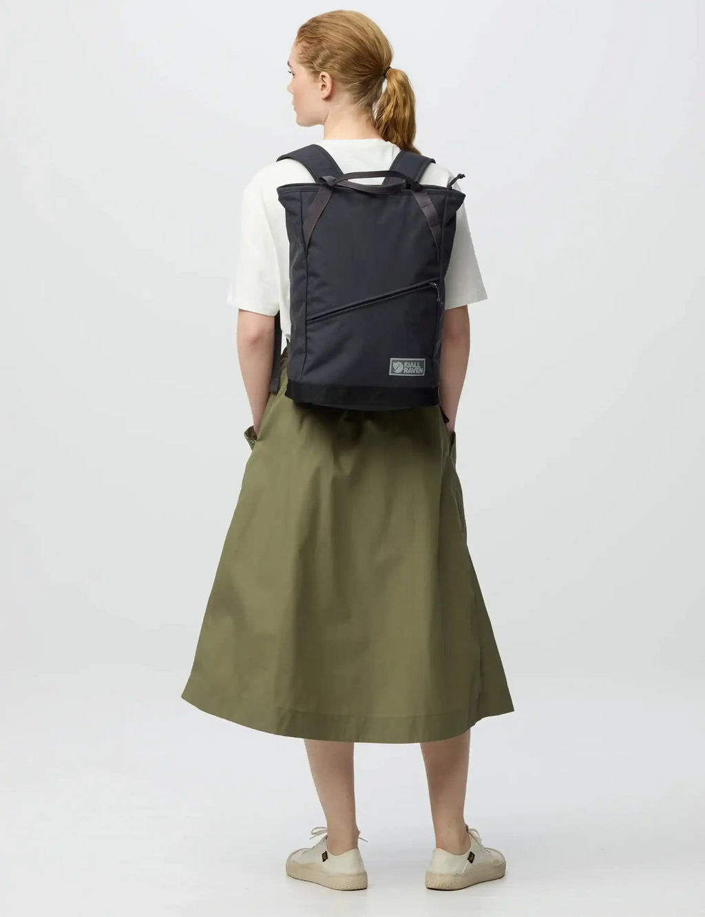 Coal black backpack worn on back, showing rear panel and straps