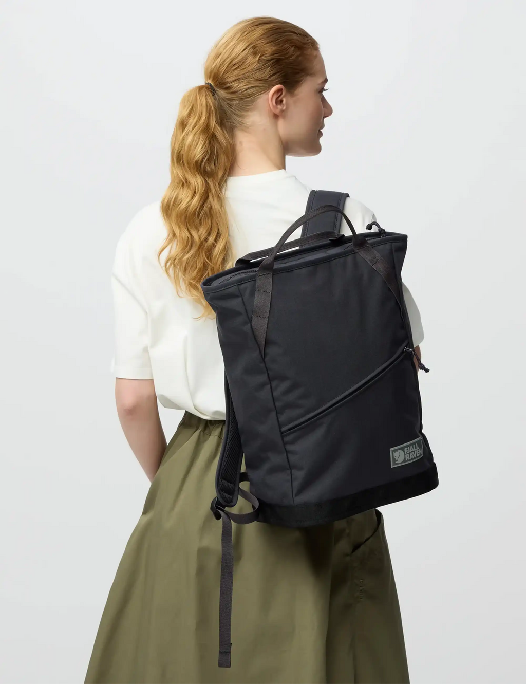 Coal black backpack worn on back, side view with adjustable straps