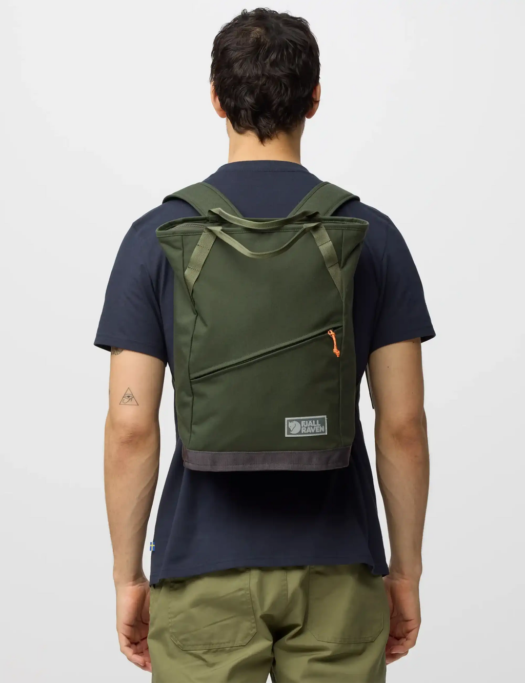 Green tote pack worn on back with shoulder straps and front logo patch